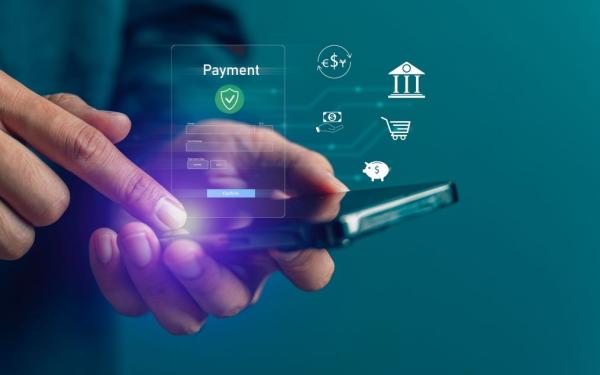 Hands holding a cell phone above which hover payment icons